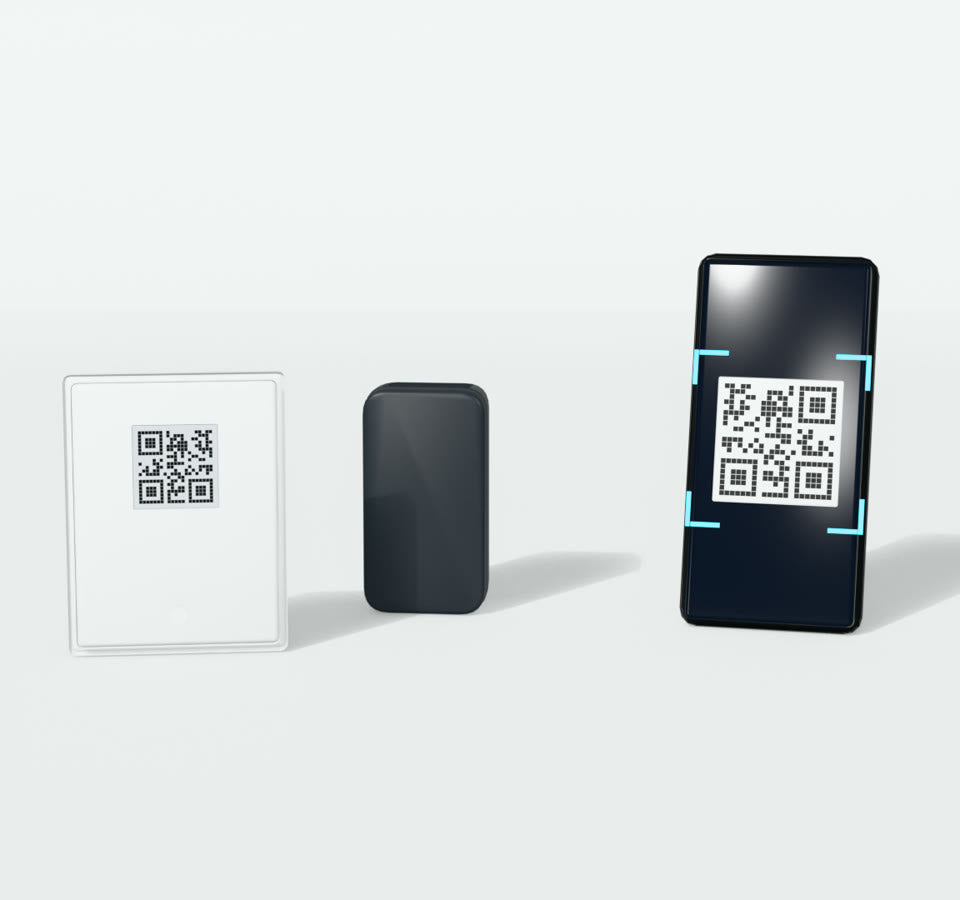 The white back cover turned over to show the QR code on its inside, with the camera and a phone scanning the code